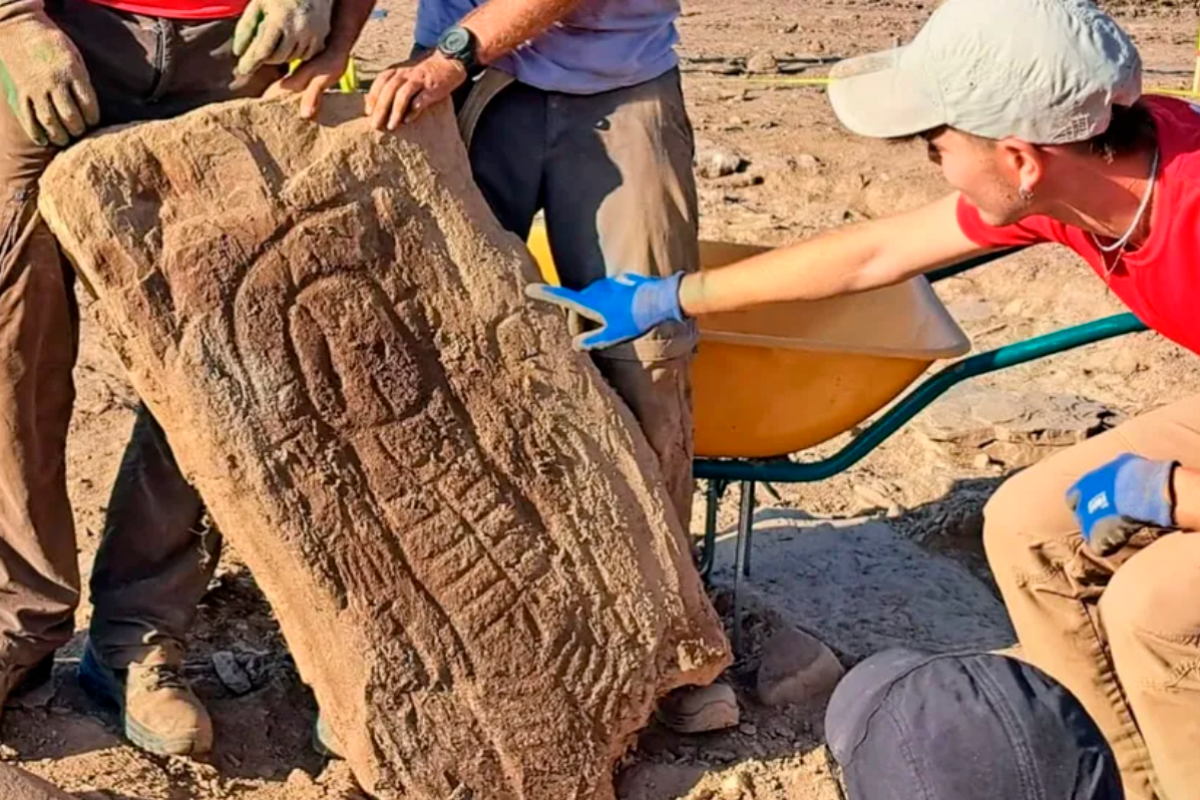 La piedra funeraria tiene una figura humana tallada con adornos femeninos.
